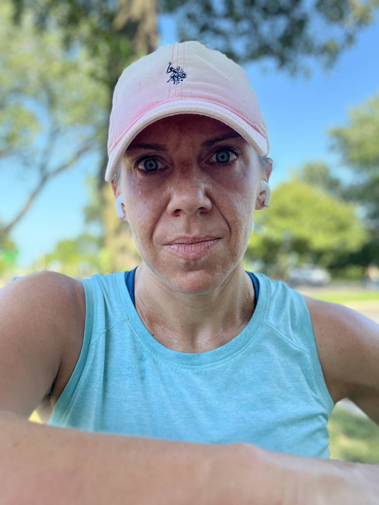 runner in blue tank and pink shirt staring at camera pensively