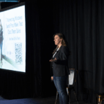 Channing Muller speaking on a stage an event